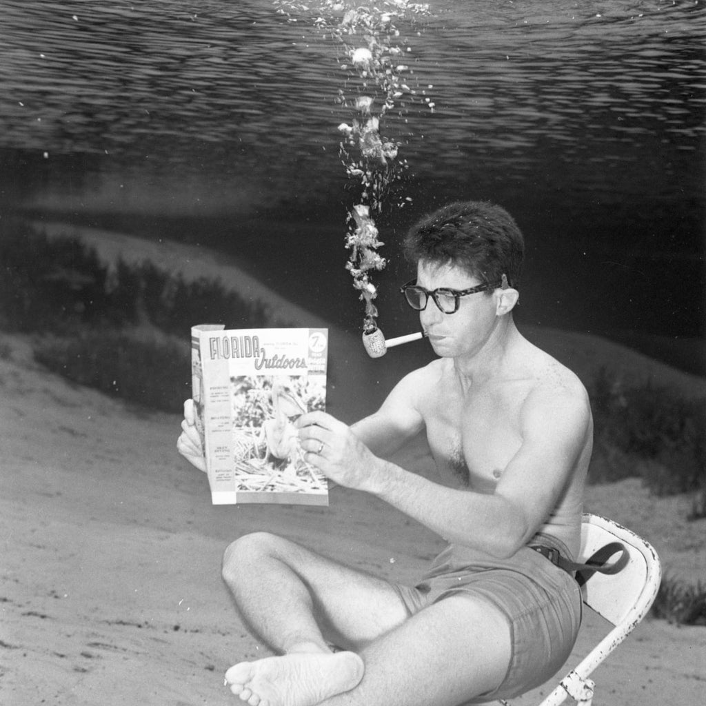 Man reading a newspaper underwater